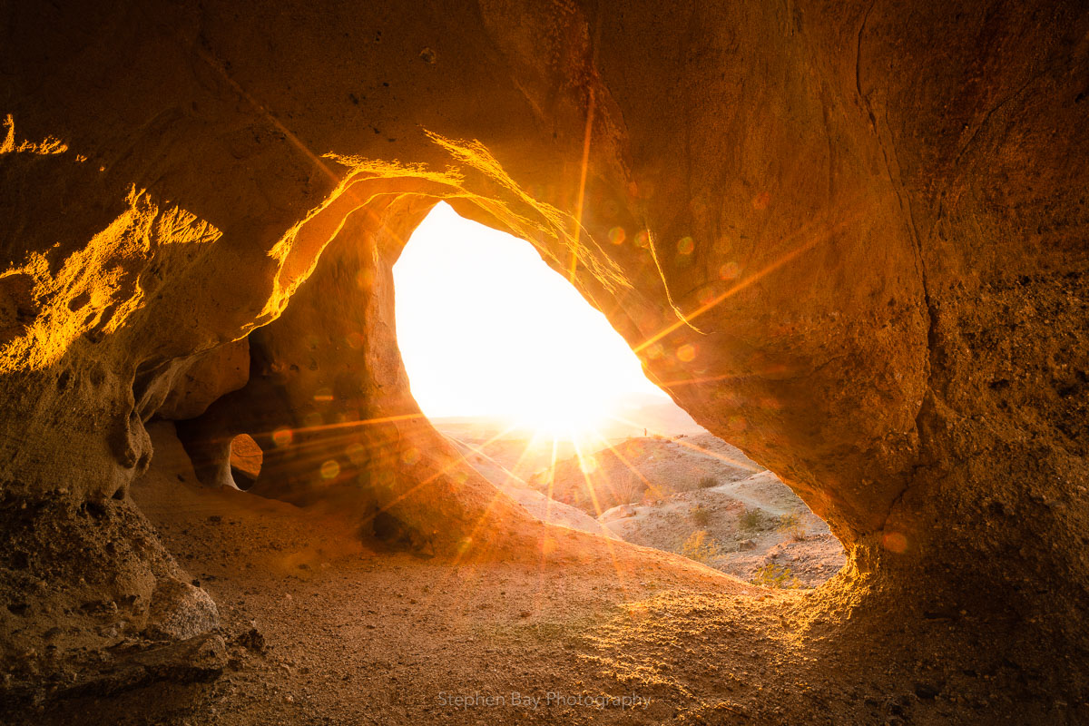Looking out of a wind cave in Anza-Borrego with the sun making beautiful light rays.