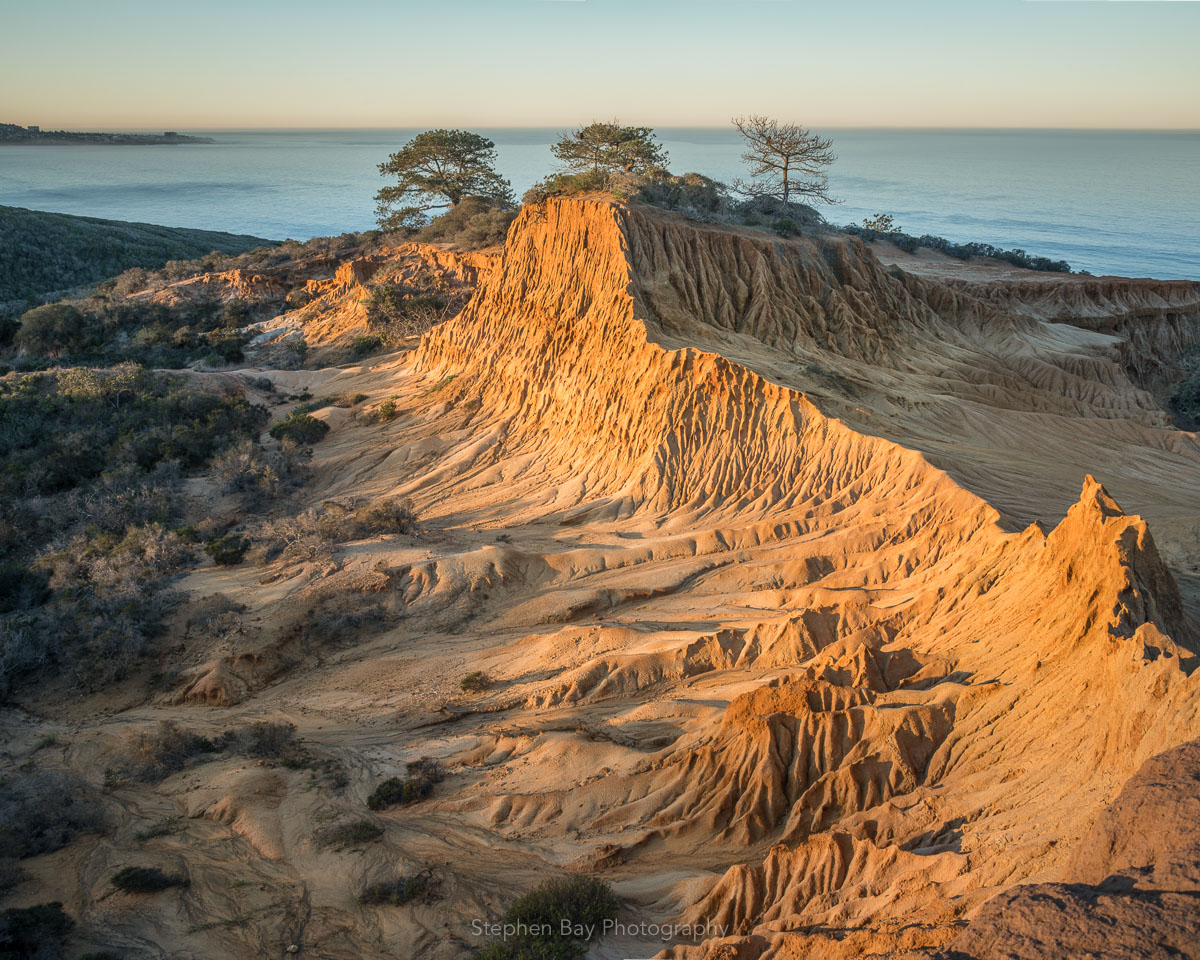 Sunrise at Broken Hill in Torrey Pines. The sun has just risen and is casting soft shadows on the eroded landscape.