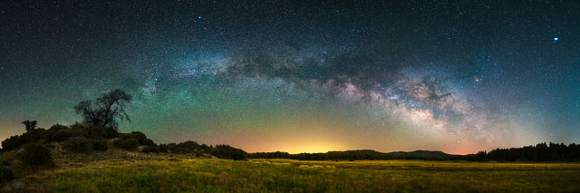 This is a panorama showing the full arch of the Milky Way over a meadow in the Cleveland National Forest.