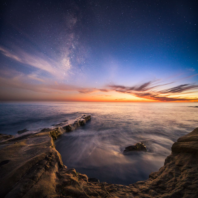 Milky way core rises as the colors from sunset fade in La Jolla Coast.