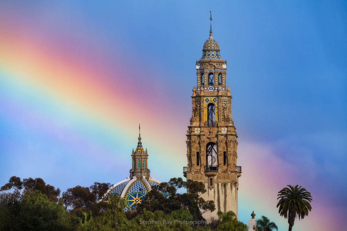 A photo of a rainbow behind the California Tower in Balboa Park.