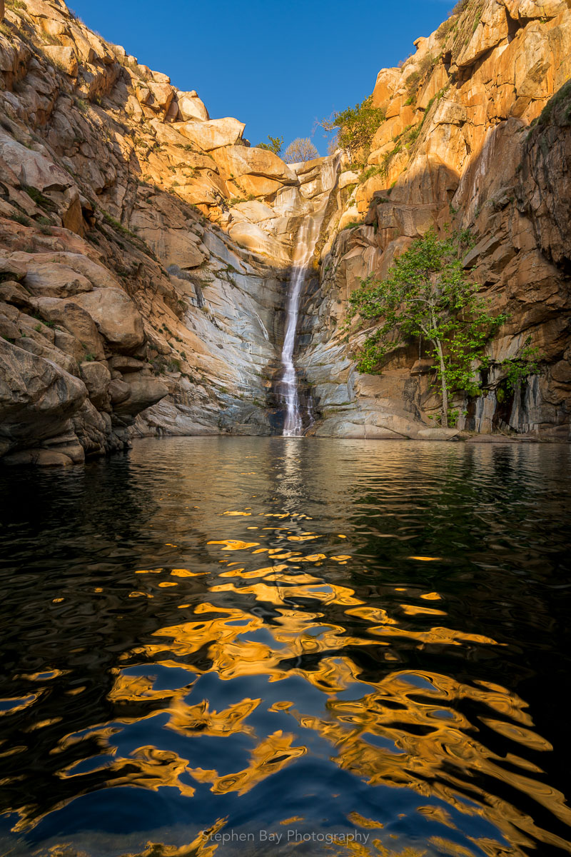 Cedar creek falls in the late afternoon. The foreground shows the pool of water with ripples and incredible golden reflections of the canyon walls.